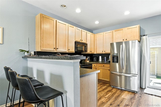 15612 E 96th Way Unit 20B, Commerce City, CO 80022 - kitchen featuring black appliances, light brown cabinets, dark countertops, a breakfast bar, and recessed lighting