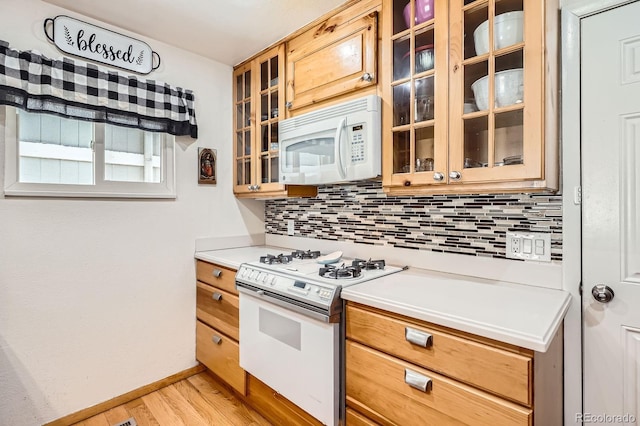 kitchen with light wood-style flooring, white appliances, baseboards, backsplash, and light countertops