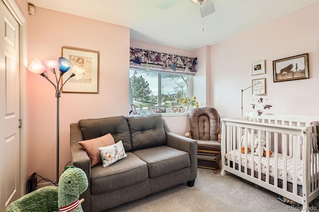 bedroom featuring a crib, a ceiling fan, and carpet floors