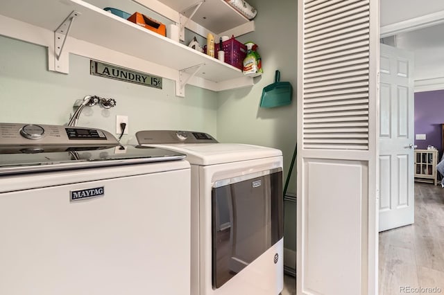 laundry room with laundry area, light wood-style floors, and washing machine and clothes dryer