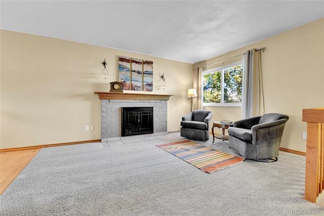 living room featuring baseboards, a textured ceiling, and a fireplace