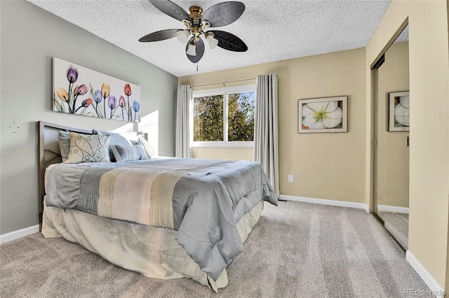 bedroom featuring a textured ceiling, baseboards, and light carpet