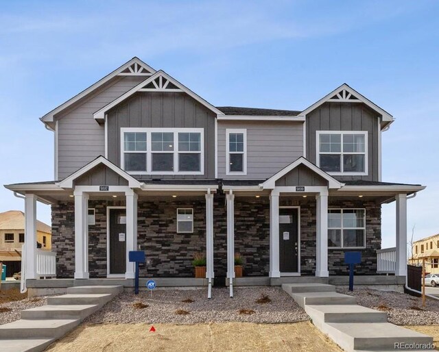 9865 Biscay St, Commerce City, CO 80022 - view of front of property featuring covered porch, stone siding, and board and batten siding