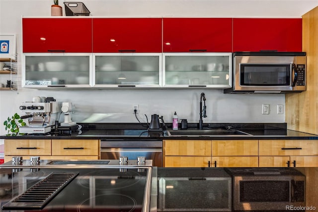 kitchen featuring electric stove, a sink, stainless steel microwave, dark countertops, and dishwasher