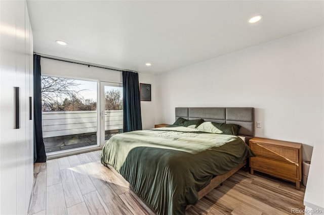 bedroom with access to exterior, recessed lighting, and wood finished floors