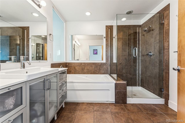 full bathroom with tile patterned floors, a stall shower, vanity, and a garden tub