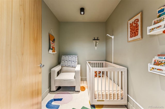 bedroom with a crib and baseboards