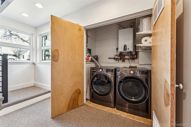 laundry area featuring baseboards, washing machine and dryer, water heater, laundry area, and recessed lighting