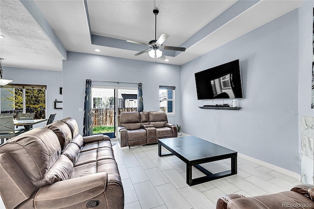 6829 Juniper Ct, Frederick, CO 80530 - living room with a textured ceiling, a tray ceiling, ceiling fan, recessed lighting, and baseboards