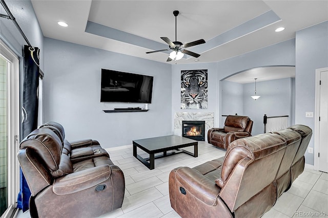 6829 Juniper Ct, Frederick, CO 80530 - living area featuring ceiling fan, a fireplace, arched walkways, baseboards, and recessed lighting