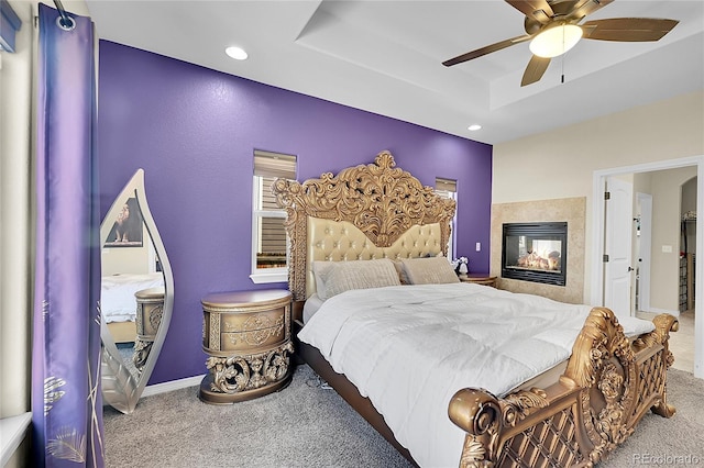 6829 Juniper Ct, Frederick, CO 80530 - bedroom with carpet floors, recessed lighting, a ceiling fan, a raised ceiling, and a multi sided fireplace