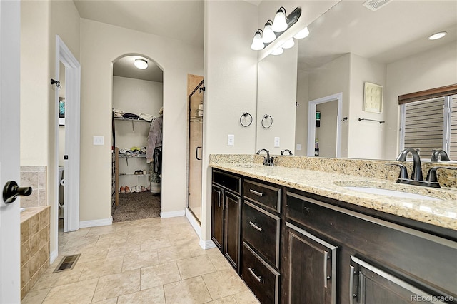 6829 Juniper Ct, Frederick, CO 80530 - full bath with a stall shower, a spacious closet, double vanity, baseboards, and tile patterned floors