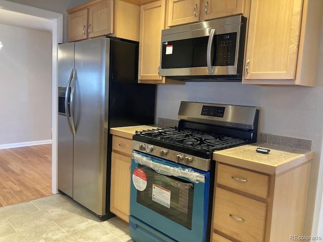 kitchen featuring appliances with stainless steel finishes and light brown cabinetry