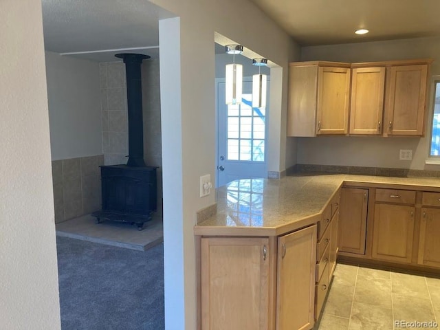 kitchen featuring a wood stove, light countertops, and light tile patterned floors