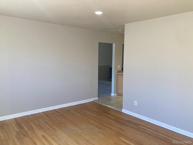 empty room with recessed lighting, baseboards, and light wood finished floors