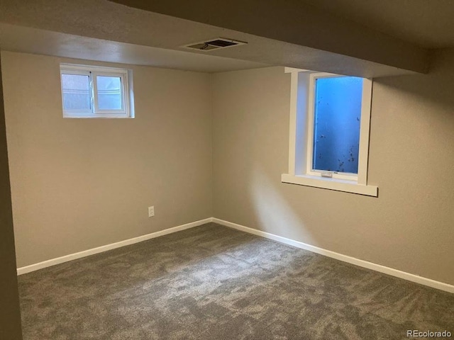 below grade area with visible vents, baseboards, and carpet flooring