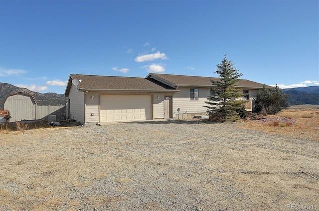 ranch-style house with a garage and a mountain view