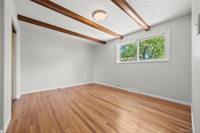 1844 S Pontiac Way, Denver, CO 80224 - spare room with beam ceiling, light wood-style flooring, baseboards, and a textured ceiling
