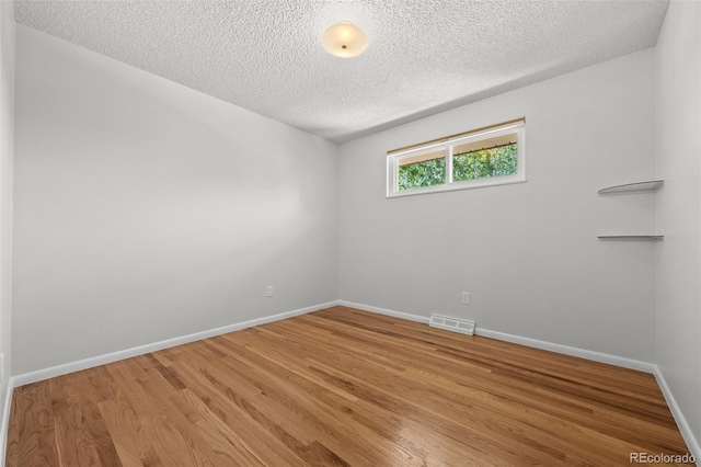 1844 S Pontiac Way, Denver, CO 80224 - empty room with light wood finished floors, a textured ceiling, and baseboards