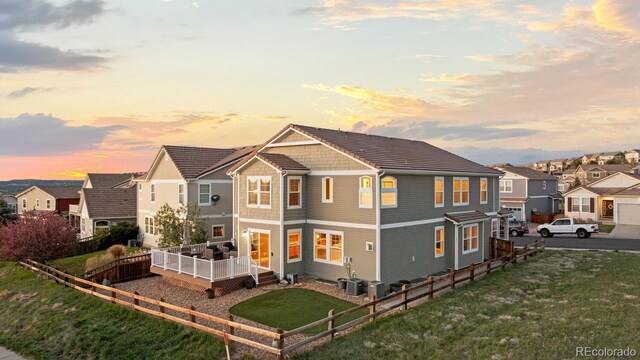 1983 Candleglow St, Castle Rock, CO 80109 - back of house at dusk featuring a residential view, fence, a yard, and a deck