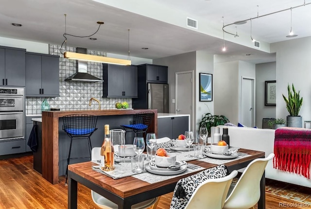 dining area with visible vents and wood finished floors