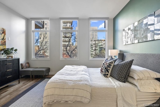 bedroom featuring multiple windows and wood finished floors