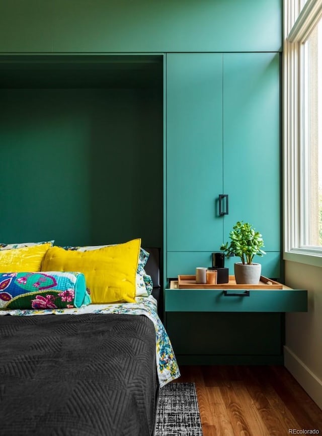 bedroom with baseboards and wood finished floors