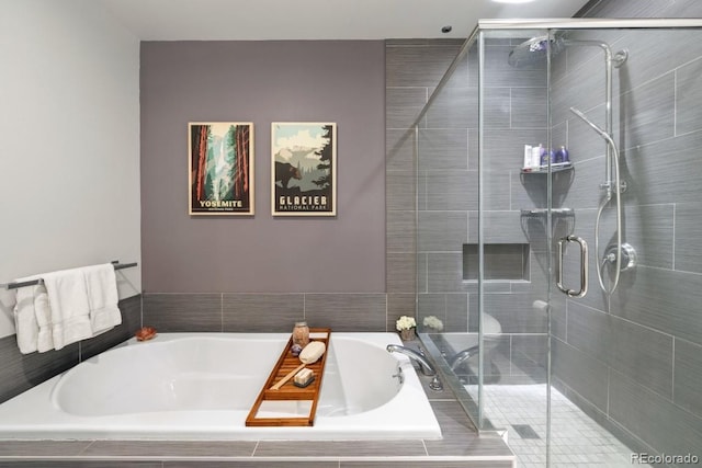 bathroom featuring a bath and a shower stall