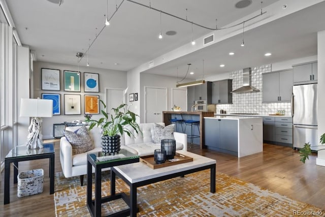 living area with visible vents and wood finished floors