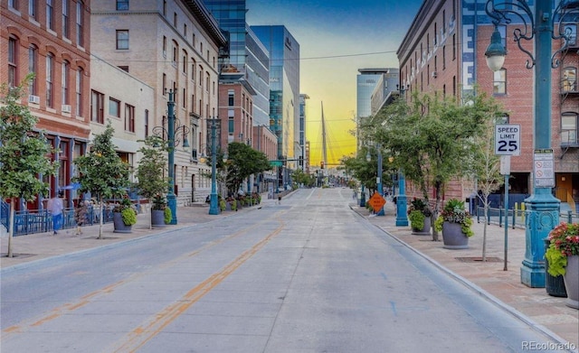 view of street featuring traffic signs, curbs, and sidewalks