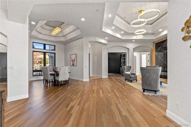 interior space with wood-type flooring and a tray ceiling