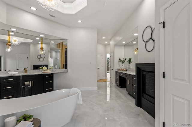 bathroom with a washtub, vanity, and an inviting chandelier