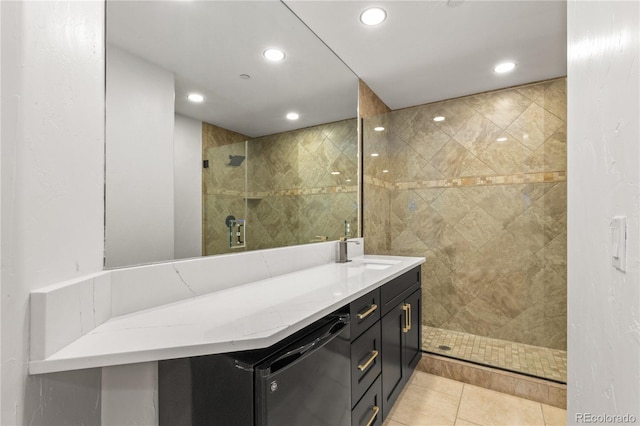 bathroom featuring tile patterned flooring, vanity, and tiled shower