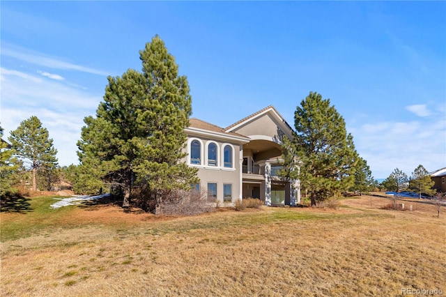 view of front of property featuring a balcony and a front yard