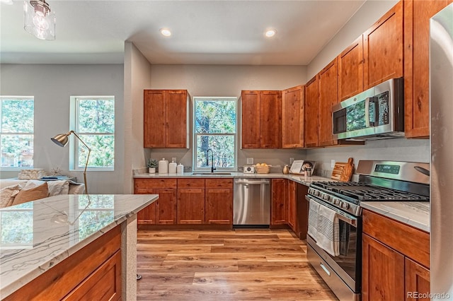 kitchen featuring stainless steel appliances, sink, and light hardwood / wood-style flooring