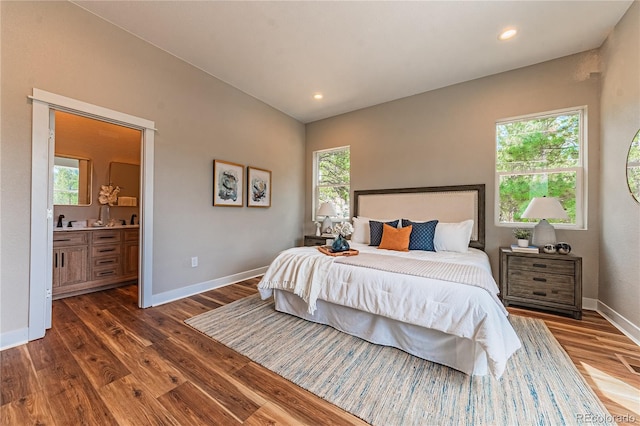 bedroom featuring dark hardwood / wood-style flooring and connected bathroom