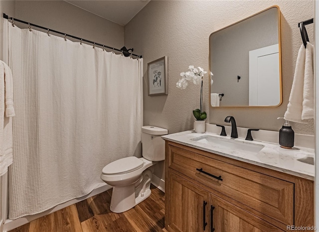 bathroom with hardwood / wood-style flooring, vanity, and toilet