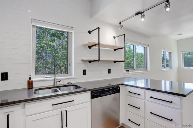 kitchen with dark countertops, dishwasher, a peninsula, and a sink