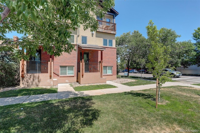 view of front of house with brick siding and a front lawn