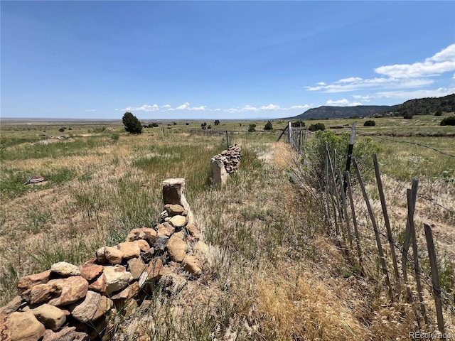 view of yard with a rural view and fence