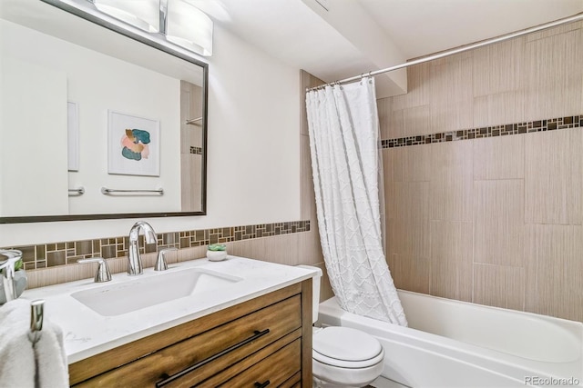 bathroom with vanity, toilet, tile walls, and shower / tub combo