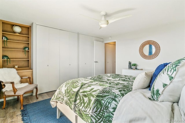 bedroom with ceiling fan, wood finished floors, and a closet