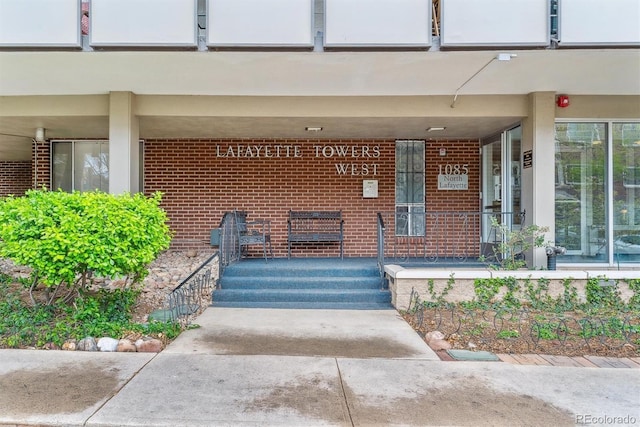 entrance to property featuring brick siding