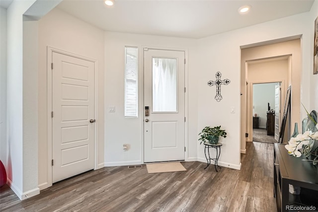 foyer with dark wood-type flooring, recessed lighting, and baseboards