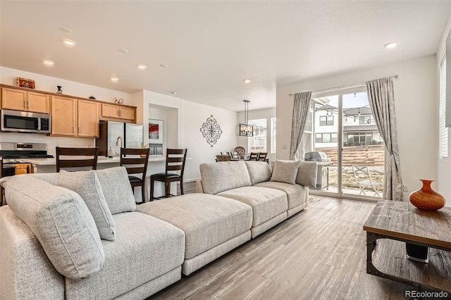 living room with light wood-style flooring and recessed lighting