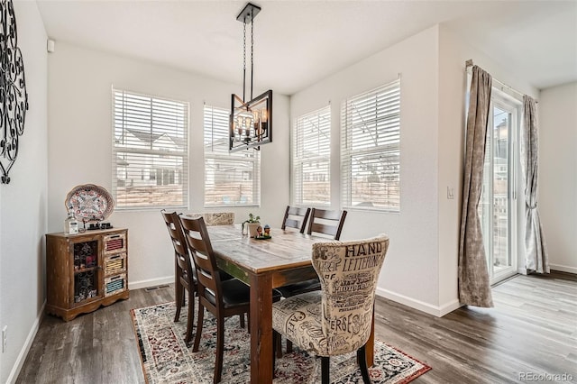 dining area with a chandelier, wood finished floors, and baseboards