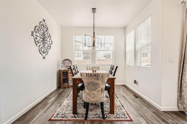 dining room with wood finished floors, baseboards, and a chandelier