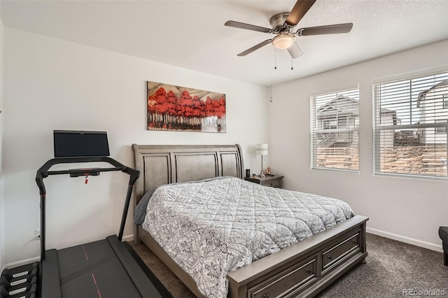 bedroom with baseboards, dark carpet, and a ceiling fan