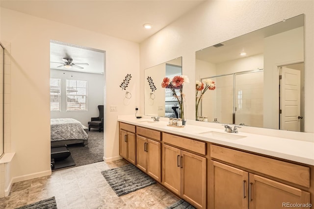 full bathroom featuring a shower stall, a ceiling fan, double vanity, connected bathroom, and baseboards