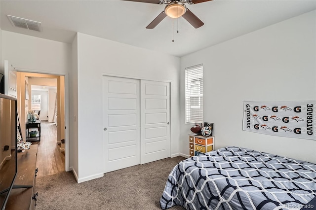 bedroom featuring multiple windows, a closet, carpet floors, and baseboards